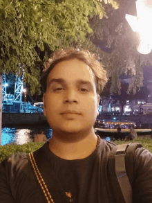 a man takes a selfie in front of a river at night