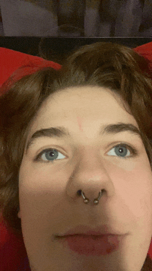 a close up of a person 's face with a nose ring on it