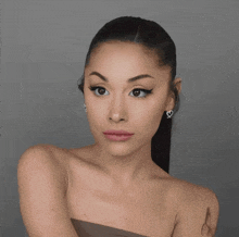 a close up of a woman 's face with a ponytail and earrings