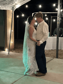 a bride and groom are dancing under a tent at their wedding