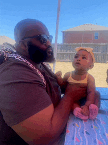 a man is holding a baby girl in his arms