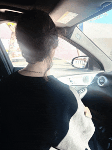 a woman in a car has a tattoo on her neck that says ' i 'm willing to go wherever '