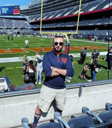 a man wearing a bears shirt stands in a stadium