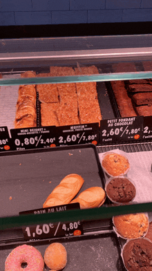 a display case contains a variety of baked goods including a muffin