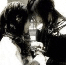 a black and white photo of two women looking into each other 's eyes .