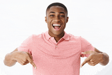 a man wearing a pink shirt is pointing at himself