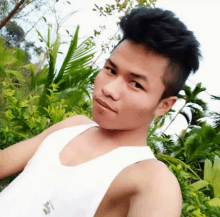 a young man wearing a white tank top with a chinese symbol on the front