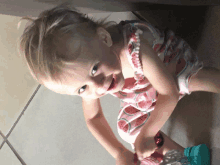 a little girl in a watermelon dress playing with a toy