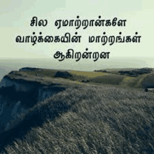 a picture of a mountain with a quote in tamil on it .