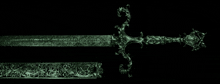 a green sword on a black background with a floral design