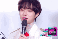a man holding a microphone in front of a sign that says comeback