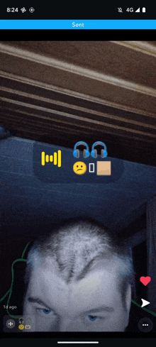 a phone screen shows a picture of a man 's head with headphones and a smiley face on it