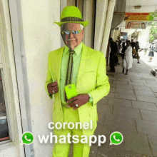 a man in a neon green suit and hat is holding a cell phone and says coronel whatsapp below him