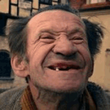 an elderly man with a missing tooth is smiling .