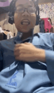 a person wearing headphones and a blue shirt is smiling .