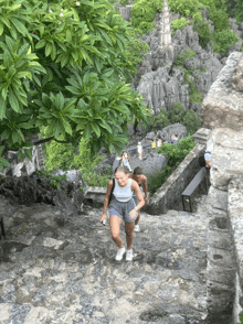 a woman walking up a set of stone stairs with a backpack