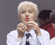 a man in a white shirt and tie is blowing a kiss with red lipstick