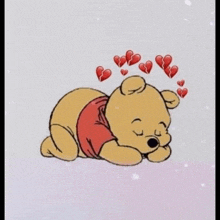 winnie the pooh is laying down with a bunch of broken hearts around his head .