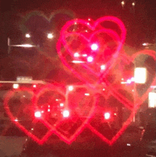 three red hearts are displayed in a window