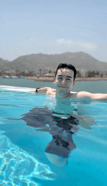 a man is swimming in a pool and smiling