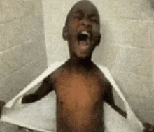 a shirtless child is taking a shower with his mouth open .