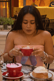 a woman sits at a table with a cup of coffee