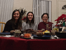 three women are sitting at a table with plates and bowls of food and a mason jar that says ' ice ' on it