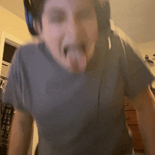 a man wearing headphones sticks out his tongue