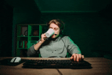 a man wearing headphones is drinking a cup of coffee while playing a video game