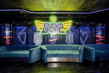 a neon sign that says b52 hangs above a couch