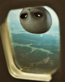 an alien is floating in the air and looking out of a plane window