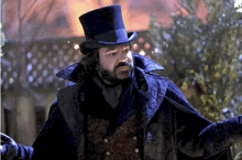 a man with a beard wearing a top hat and cape .