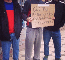 a man is holding a cardboard sign that says " cectpbi "