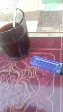 a blue lighter sits next to a cup of coffee on a table