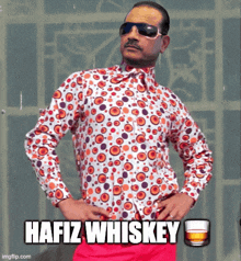 a man wearing a polka dot shirt and sunglasses says ' hafiz whiskey '