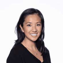 a woman in a black shirt is smiling for the camera .