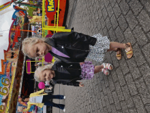 two little girls are standing in front of a carnival ride that says magic