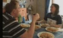 a man and a woman are sitting at a table with plates of food and a pepsi can in the background