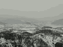 a snowy landscape with a few buildings in the foreground