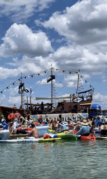 a pirate ship is surrounded by rafts and people