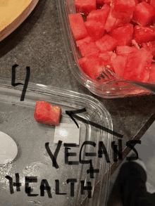 a plastic container with watermelon slices and the words " vegans + health " written on it