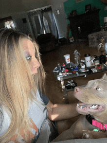 a woman and a dog are looking at each other and the dog has a pink collar