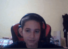 a young boy wearing headphones is sitting in a chair in a bedroom .