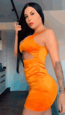 a woman in an orange dress with a cut out on the side