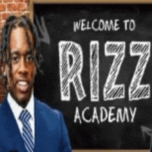 a man in a suit and tie is standing in front of a chalkboard that says welcome to rizz academy