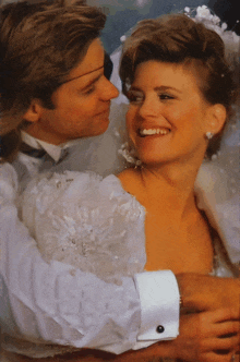 a man in a tuxedo is hugging a woman in a white wedding dress