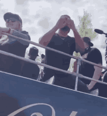 a group of people are standing on top of a bus .