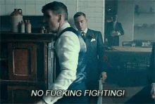 a man in a suit is holding a knife and says `` no fucking fighting ! ''