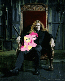 a man is sitting in a chair with a pink pony on his lap and the website megadeth.com is below him