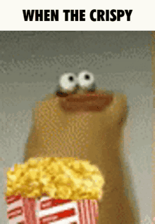 a cartoon character is holding a bucket of popcorn and says " when the crispy " on the bottom